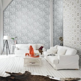 Helles Wohnzimmer mit weißen Sofas, modernen Tapeten und dekorativem Kuhfellteppich.