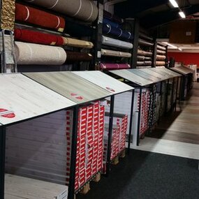 Ausstellung von Laminatböden und Teppichrollen in einem Fachgeschäft für Bodenbeläge.