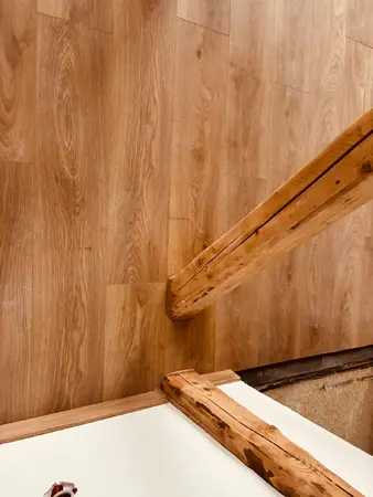 Holztreppe mit Eichenparkett und sichtbaren Holzbalken im Innenraum