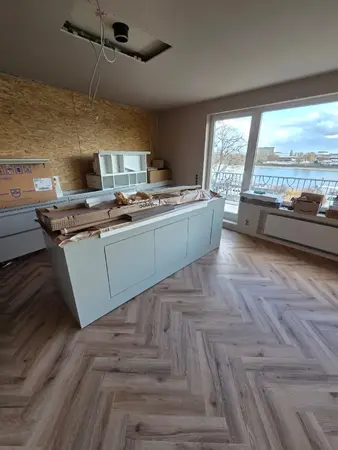 Küchenmontage im Neubau: Kücheninsel, Kartons, offene Decke, Balkonblick