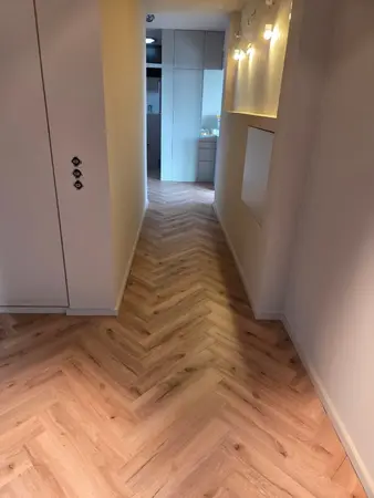 Schmaler Flur mit Eichenparkett im Fischgrätmuster und Einbauschrank